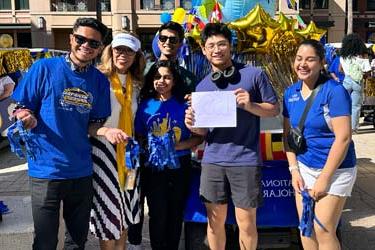 A group of international students stand in front of a building at San José State University.